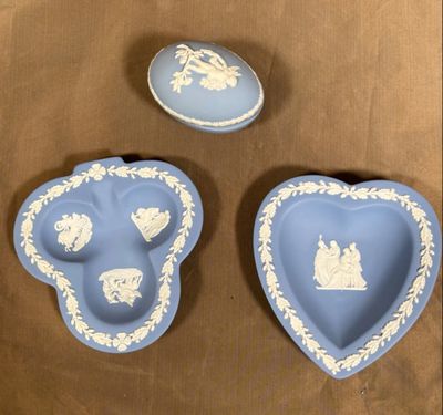 trois assiettes bleues et blanches en forme de cœur posées sur une table marron