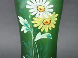 a green vase with flowers painted on it