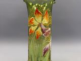 un vase vert orné de fleurs peintes