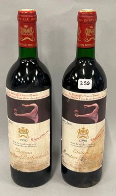 two bottles of red wine sitting next to each other on a table