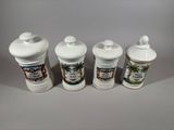 three white ceramic containers sitting on top of a gray surface