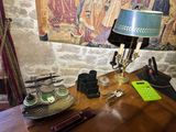 a desk with a lamp, a lamp shade, and other items on it