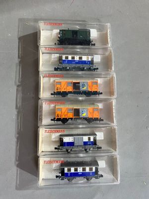 six petits trains dans une boîte en plastique posée sur une table