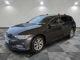 a grey volkswagen passat is parked in a room with a checkered floor