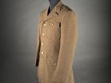 a brown coat on a mannequin stand against a gray background
