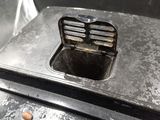 a metal box with a hole in it on the ground