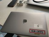 a laptop computer sitting on top of a desk next to a cell phone