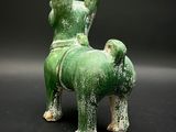 a green statue of a dog on a black background