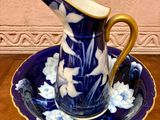 a blue and white pitcher and a plate on a table