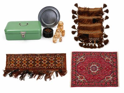 quatre tapis et une valise posés sur une surface blanche