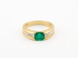 une bague en or sertie d'une émeraude et de diamants