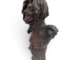 bronze bust of a woman wearing a headscarf on a white background