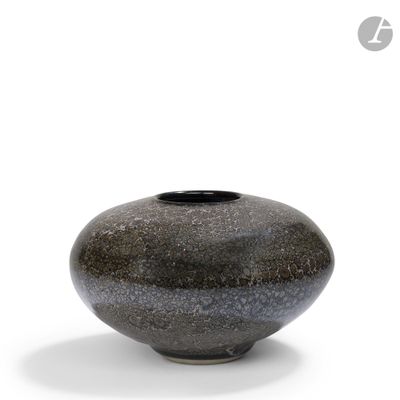 a black and gray vase sitting on a white surface
