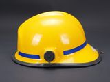 a close up of a yellow hard hat on a black background