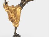 statue of a woman in a golden dress on a black base
