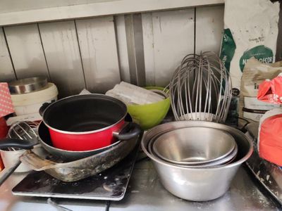 pots and pans sit on top of a stove with a whisk and whisk whisk in the background