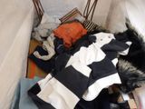 a pile of clothes on the floor next to a chair