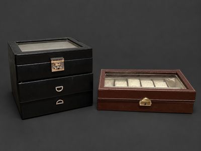 two black and brown boxes with glass lids on a black background