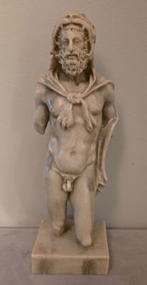 une statue représentant un homme barbu vêtu d'une cape