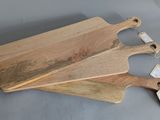 three wooden cutting boards with tags on them sitting on a table
