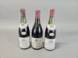 three bottles of wine are lined up on a table