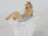 a figurine of a woman sitting in a bathtub