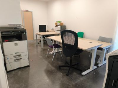 une pièce équipée d'un bureau, d'une imprimante et d'un photocopieur