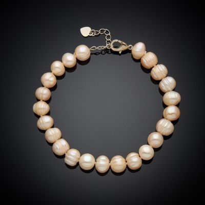 un bracelet de perles blanches avec un fermoir en or