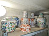 de nombreux vases de toutes sortes posés sur une étagère dans une pièce