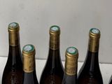 several bottles of wine are lined up in a row on a counter