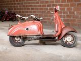 a red scooter parked in front of a brick wall