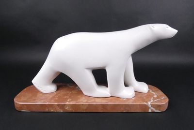 sculpture en marbre représentant un ours polaire, posée sur un socle en marbre, sur fond noir