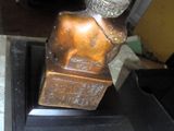 une statue en bronze représentant un homme assis sur une table