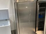 two stainless steel refrigerators next to each other in a room