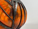 an orange vase with a knot around it on a table