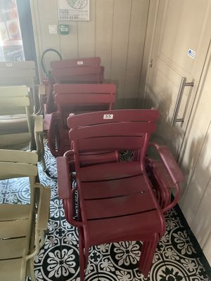 de nombreuses chaises rouges alignées dans un coin de la pièce