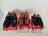 trois paires de chaussures noires et marron posées sur une boîte rouge