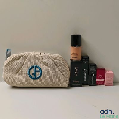 a small bag with a blue peace sign on it next to some cosmetics