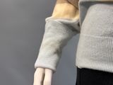 a male mannequin wearing a sweater and black pants