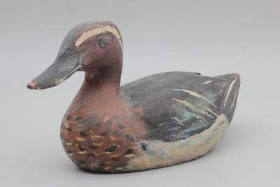 un canard en bois posé sur une table