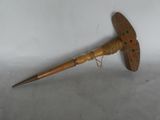 an old wooden stick with a wooden handle on a white surface