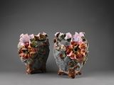 pair of ceramic vases with flowers on them on a gray surface