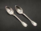 a pair of silver spoons sitting on top of a table