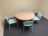 a round table with four chairs around it in a room