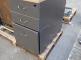 une armoire métallique à tiroirs posée sur une palette dans un entrepôt