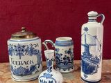 trois vases bleus et blancs posés sur une table, avec un mur rouge en arrière-plan
