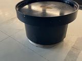 a black bowl sitting on the floor in front of a window