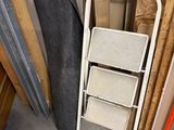 a stack of ladders next to a pile of wood