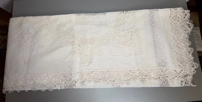 a white table cloth with lace on it on a table