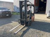 un chariot élévateur garé devant un bâtiment